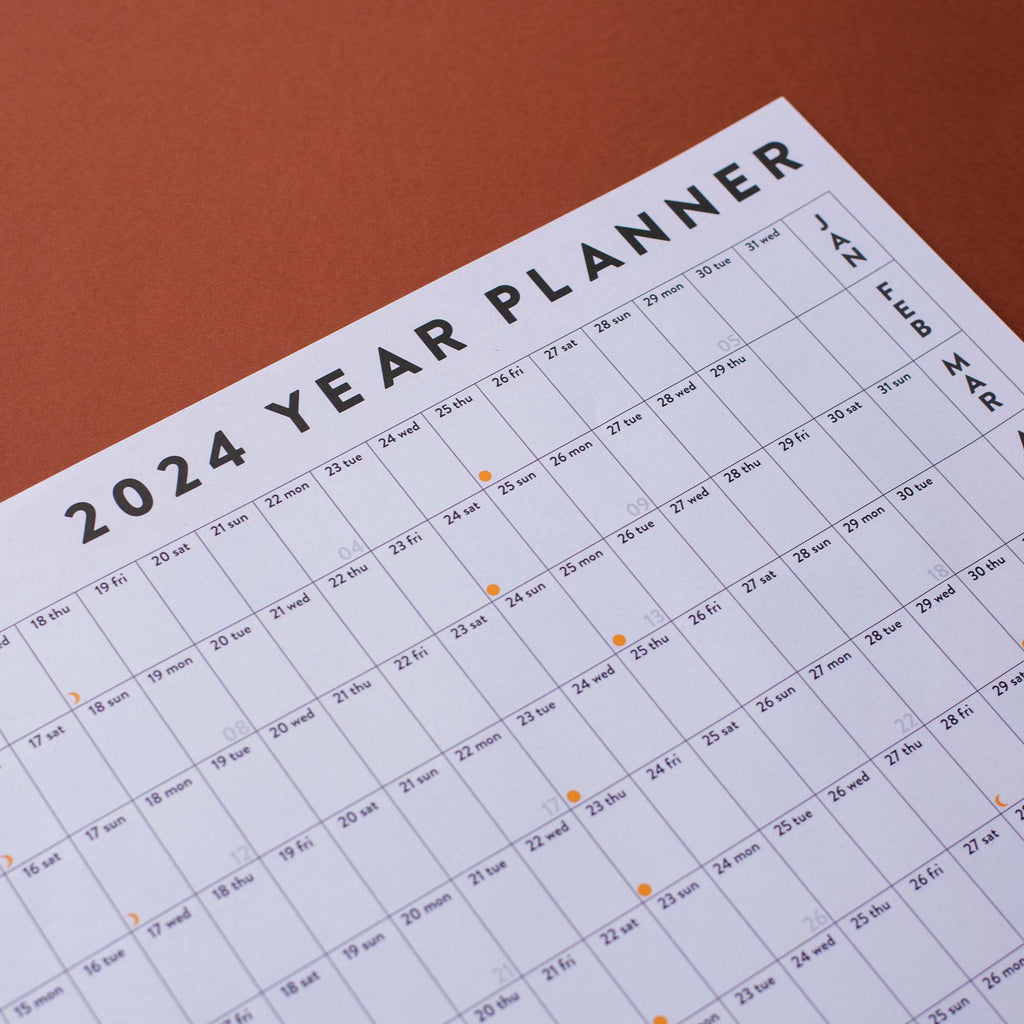 2024 wall planner. black and white. 100% recycled paper. made in the UK. highlighted weekends. week numbers. moon phases.